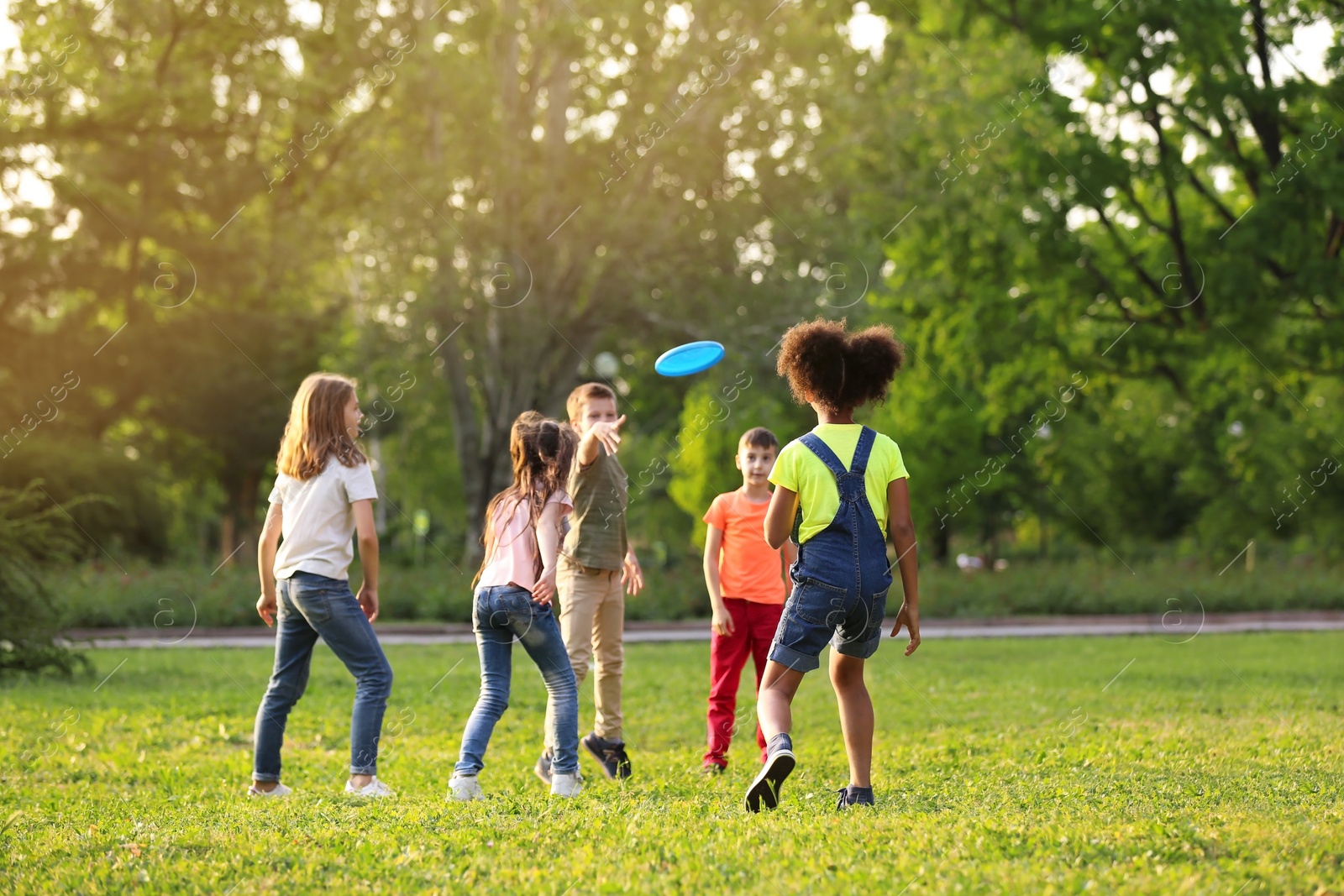 Photo of Cute little children playing with frisbee outdoors on sunny day