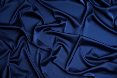 Photo of Crumpled dark blue silk fabric as background, top view