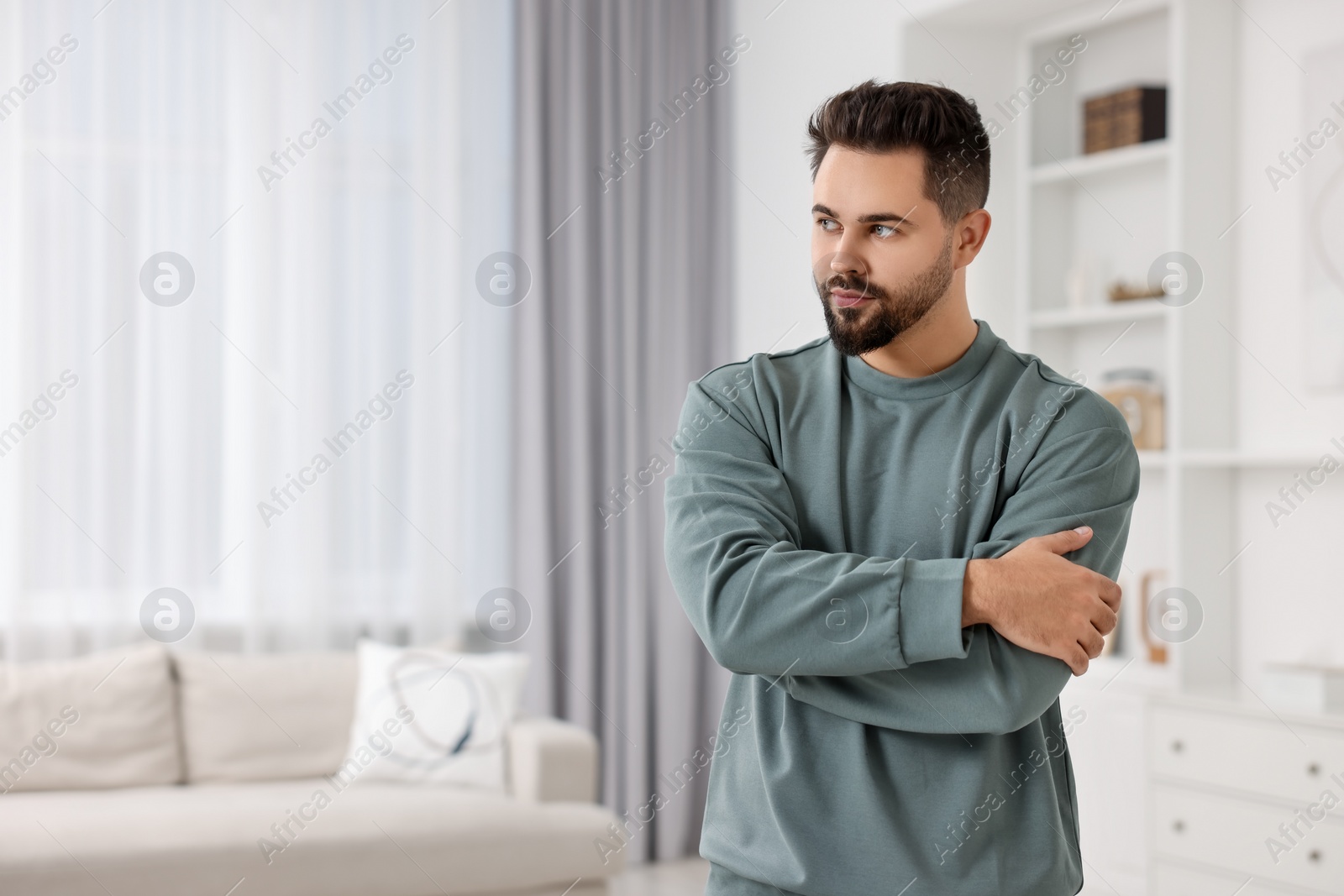 Photo of Handsome man in stylish sweater at home, space for text