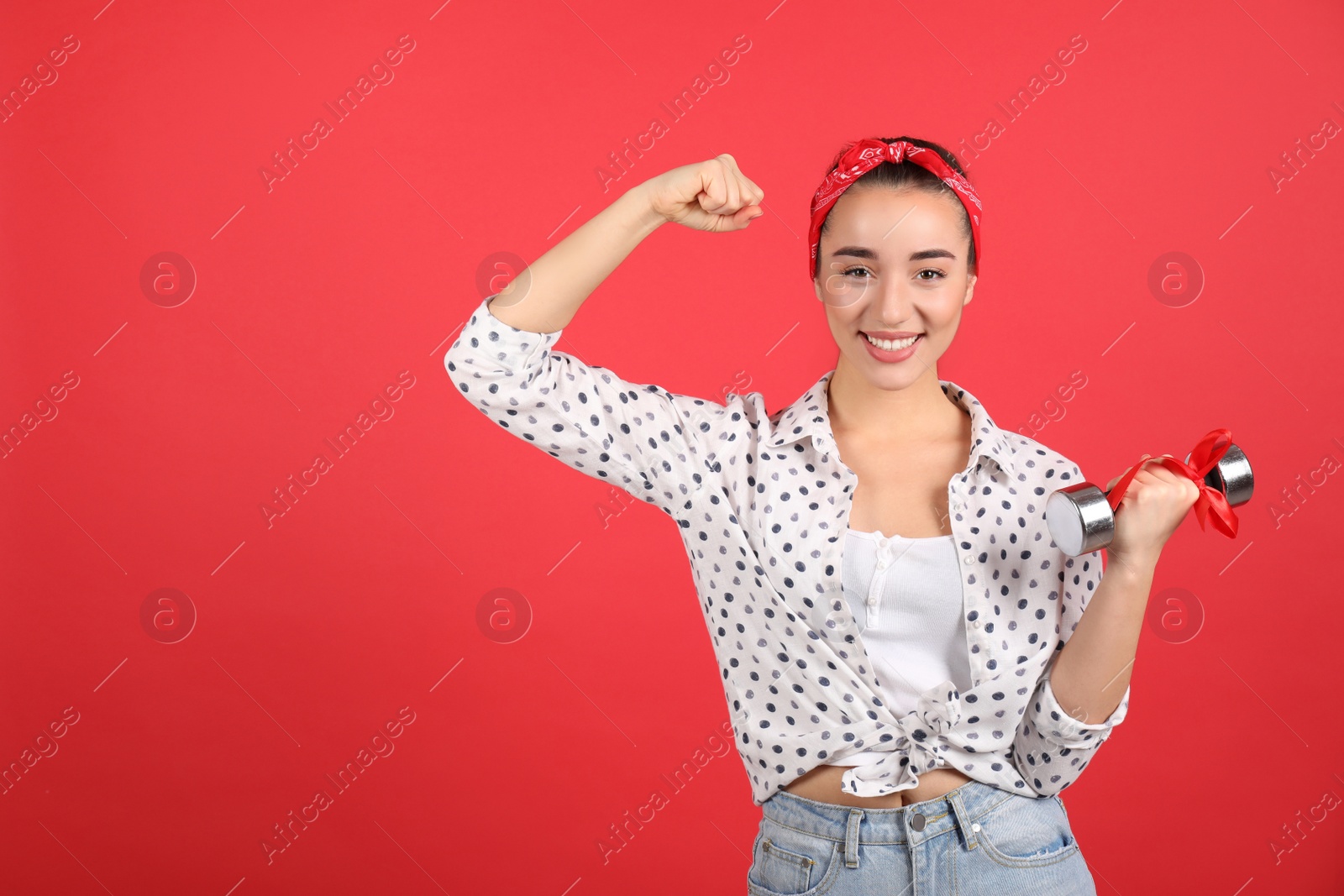 Photo of Woman with dumbbell as symbol of girl power on red background, space for text. 8 March concept