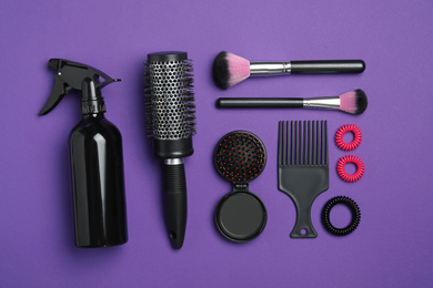 Photo of Flat lay composition with modern hair comb and brush on purple background
