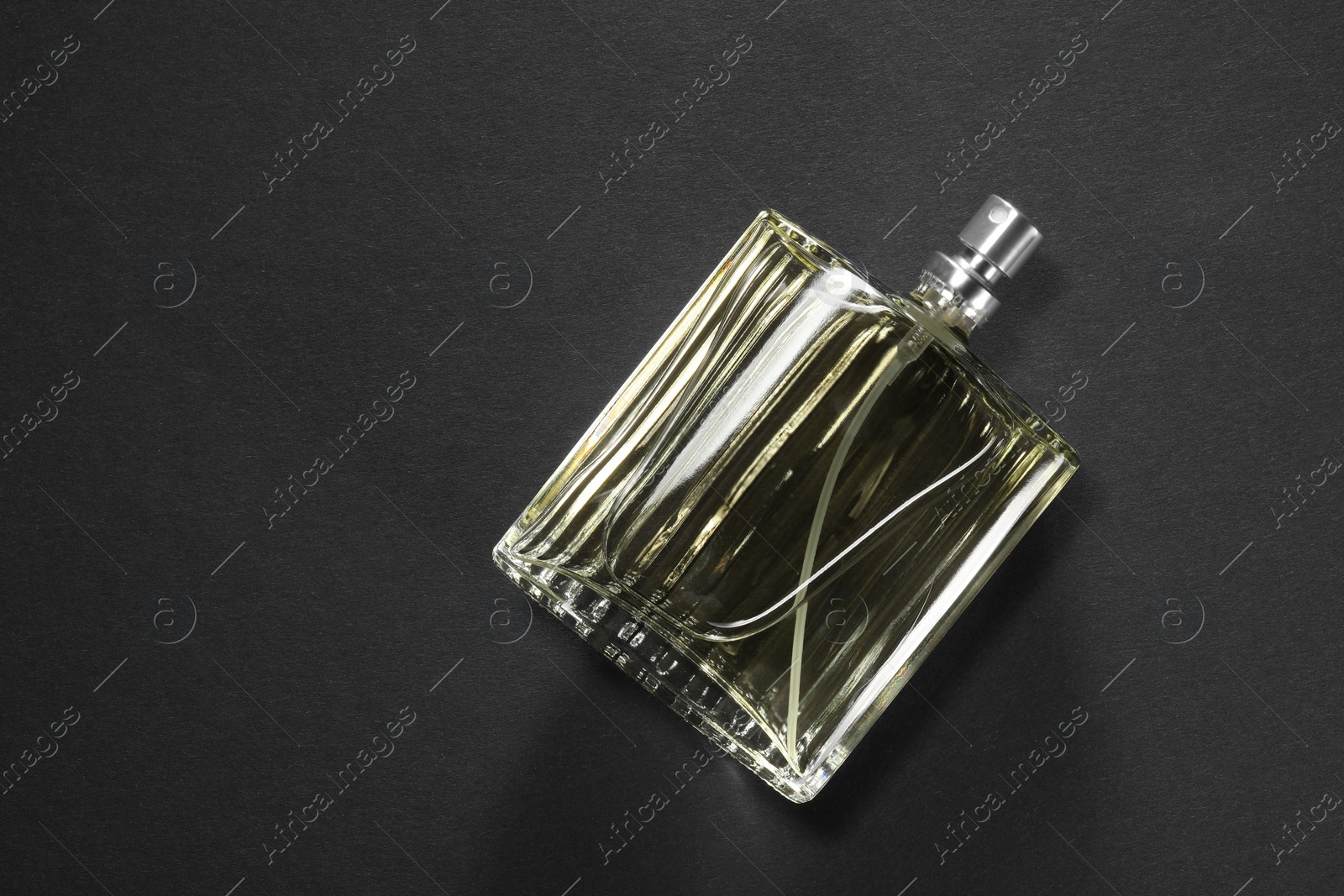 Photo of Luxury men`s perfume in bottle on black background, top view. Space for text