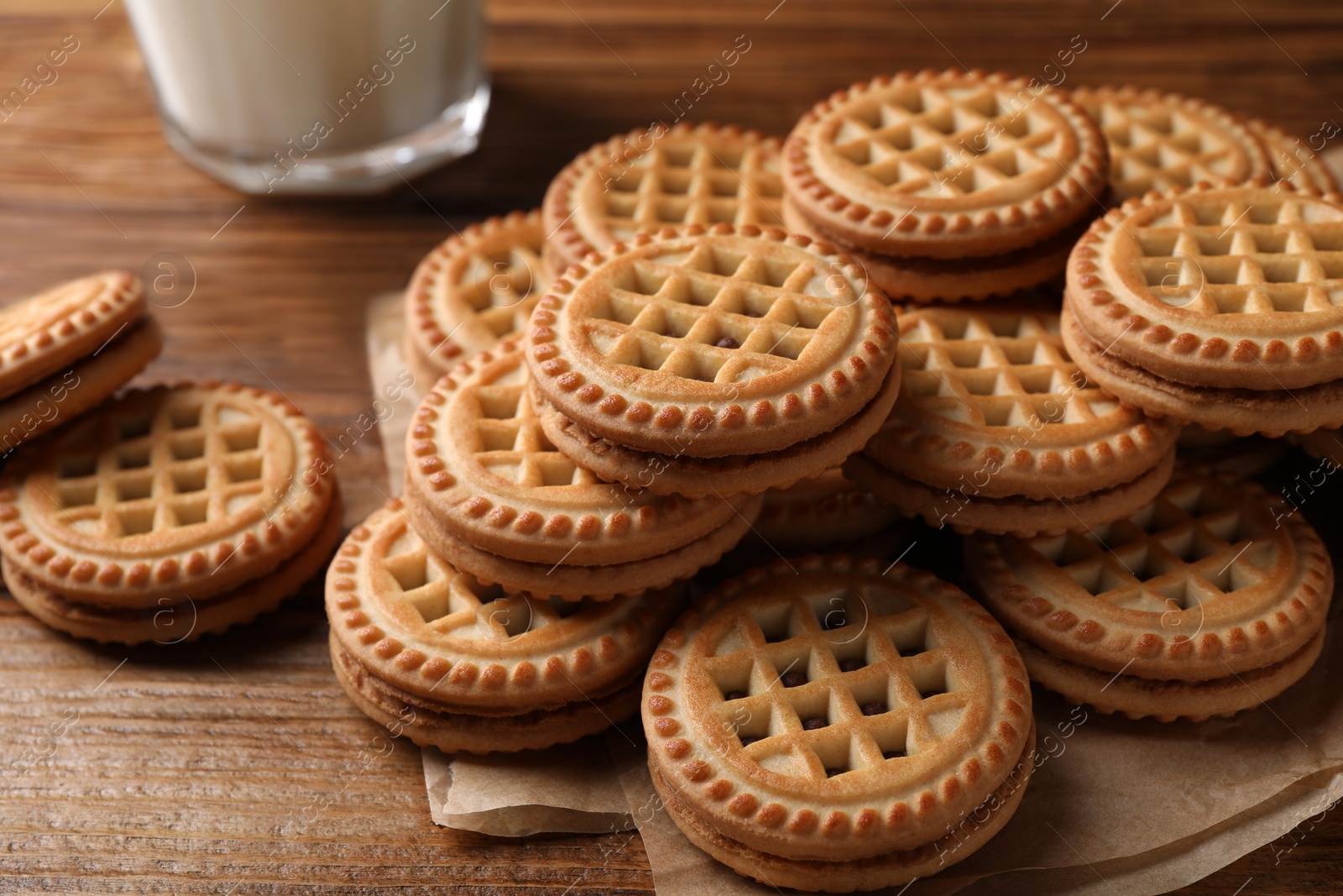 Photo of Tasty sandwich cookies with cream on wooden table, closeup