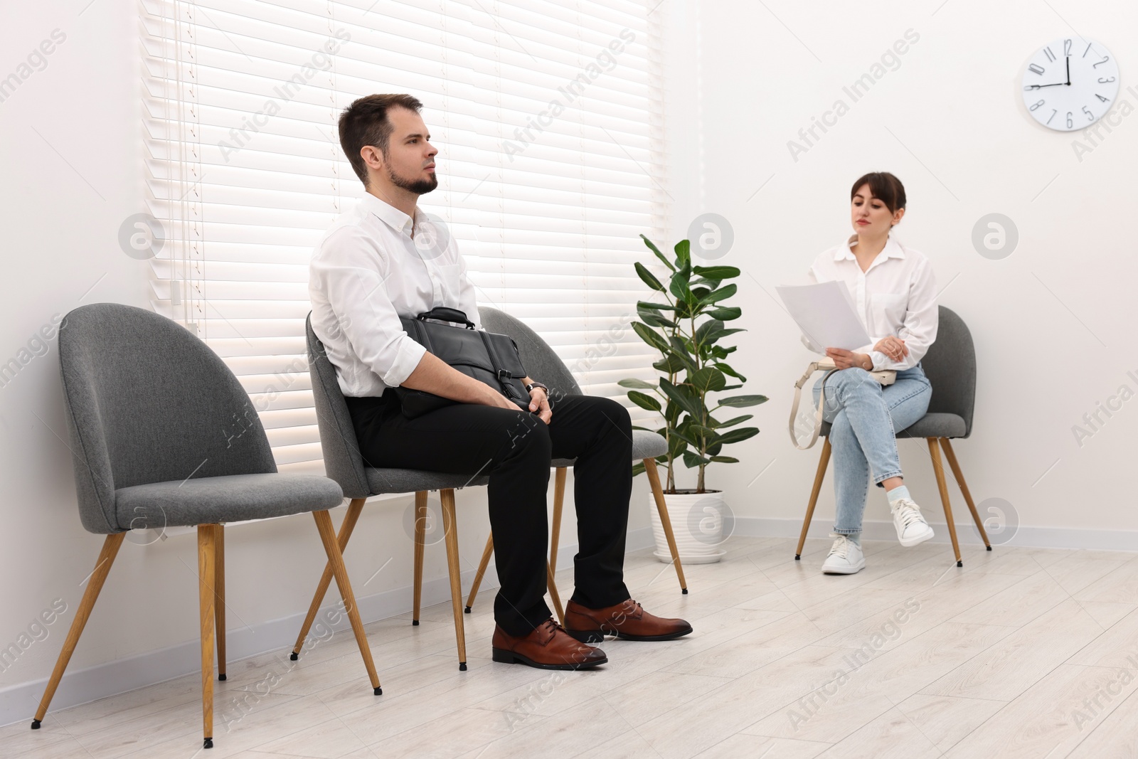 Photo of Man and woman waiting for job interview indoors