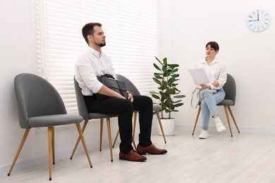 Photo of Man and woman waiting for job interview indoors