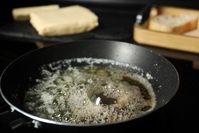 Photo of Melting butter in frying pan on black table, closeup