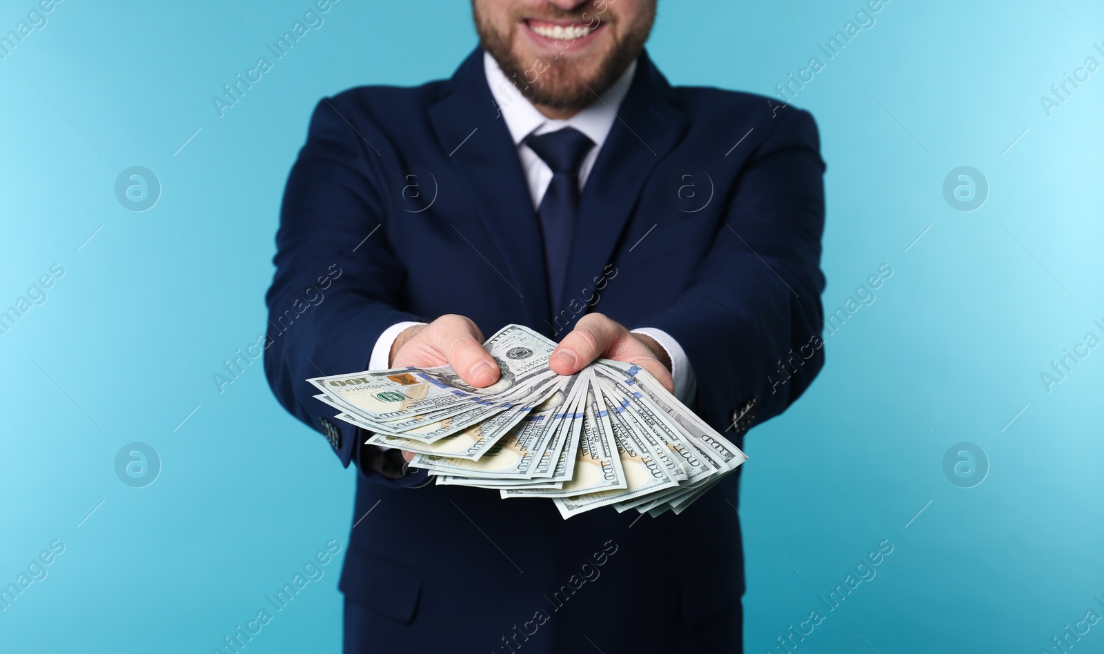 Photo of Businessman holding money on color background, closeup