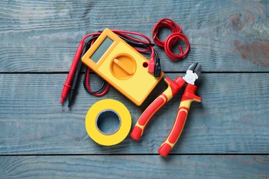 Flat lay composition with electrician's tools and accessories on blue wooden background