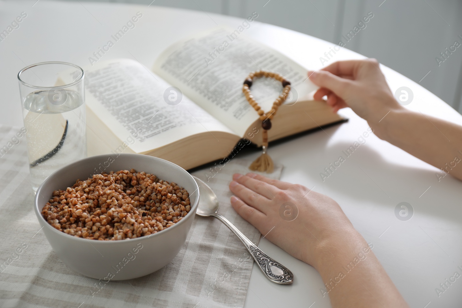 Photo of Woman with Bible having dinner at home, closeup. Great Lent season