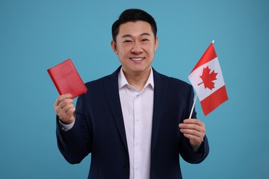 Photo of Immigration. Happy man with passport and flag of Canada on light blue background