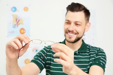 Photo of Young man with glasses visiting ophthalmologist