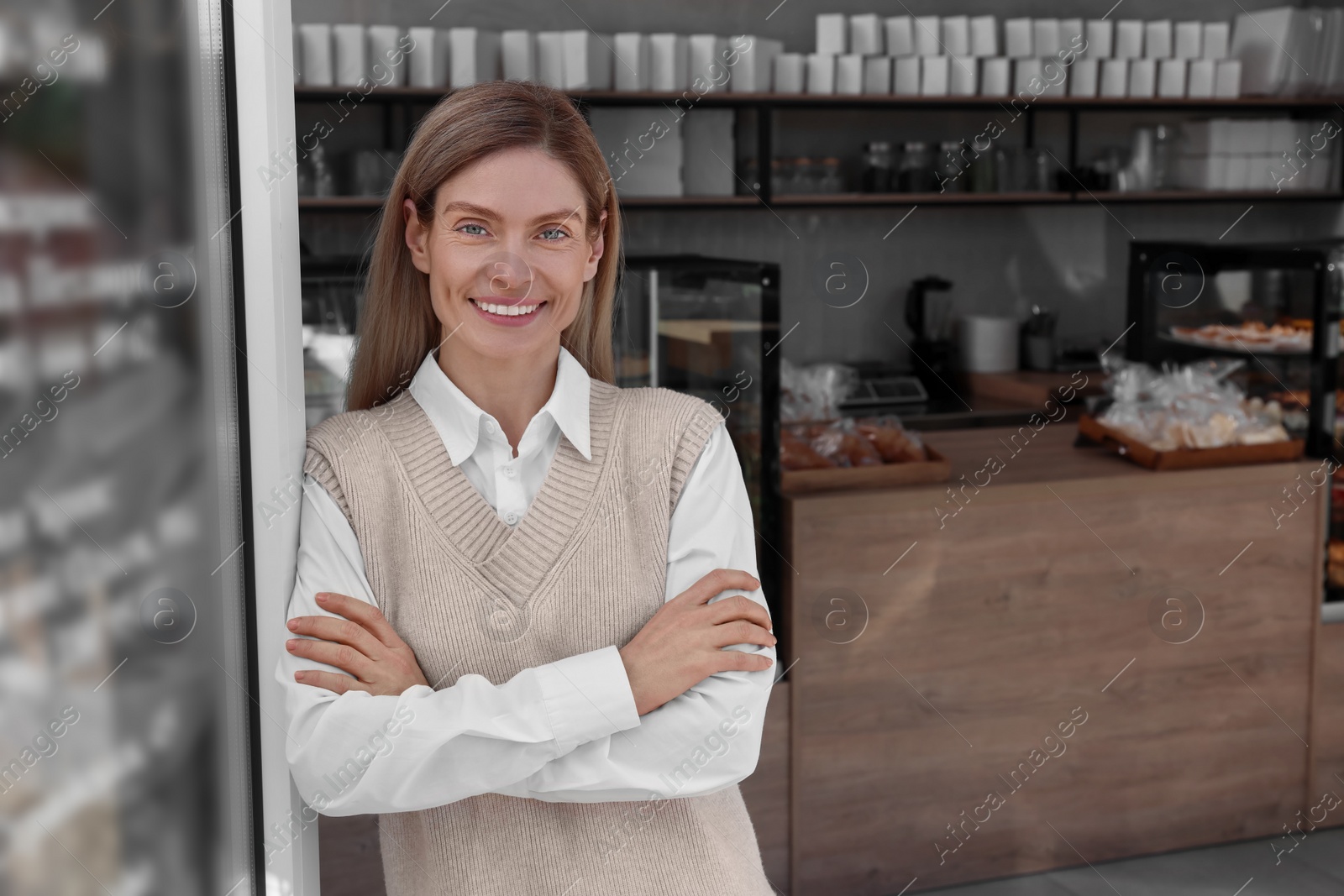 Photo of Happy business owner in bakery shop. Space for text