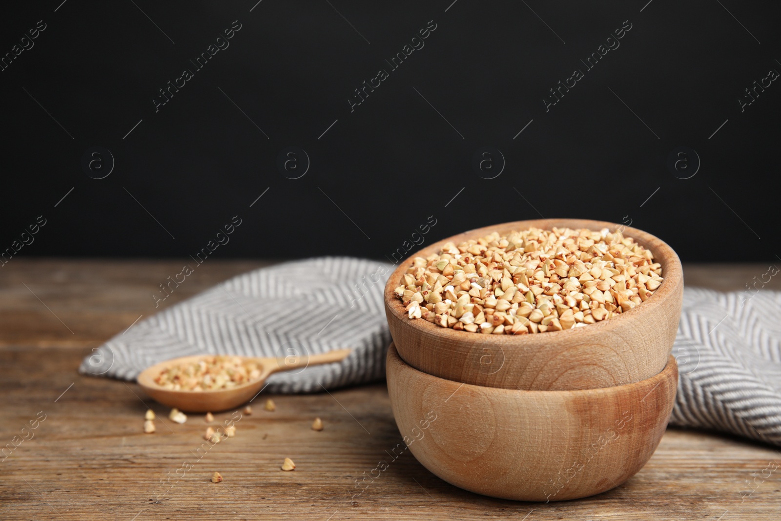 Photo of Green buckwheat on wooden table, space for text