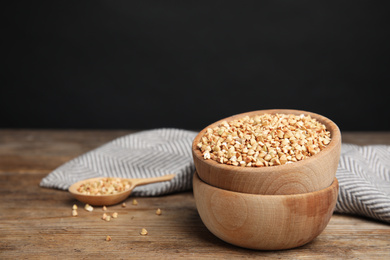 Green buckwheat on wooden table, space for text