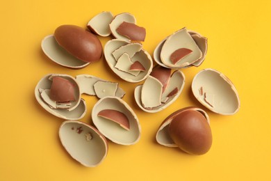 Sveti Vlas, Bulgaria - July 3, 2023: Broken halves of Kinder Surprise Eggs on yellow background, flat lay