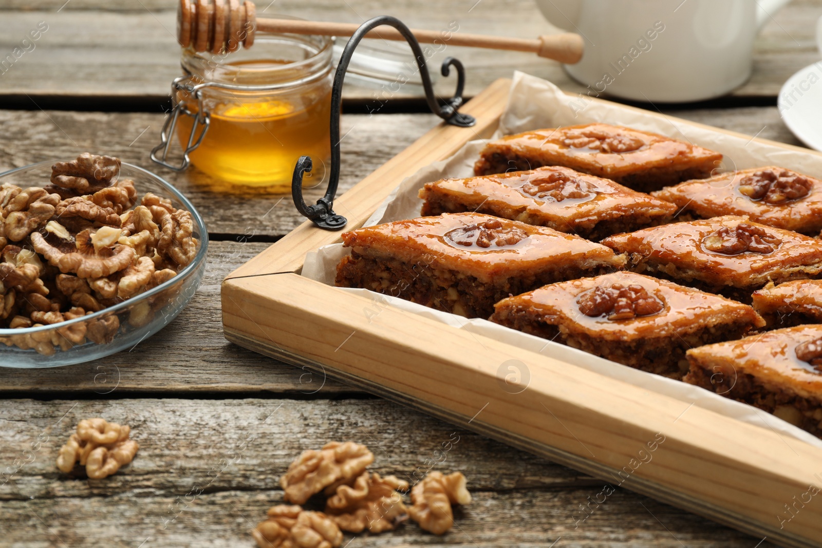 Photo of Delicious sweet baklava with walnuts on wooden table, closeup