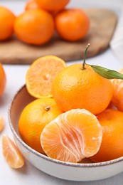 Photo of Fresh juicy tangerines on light grey table, closeup