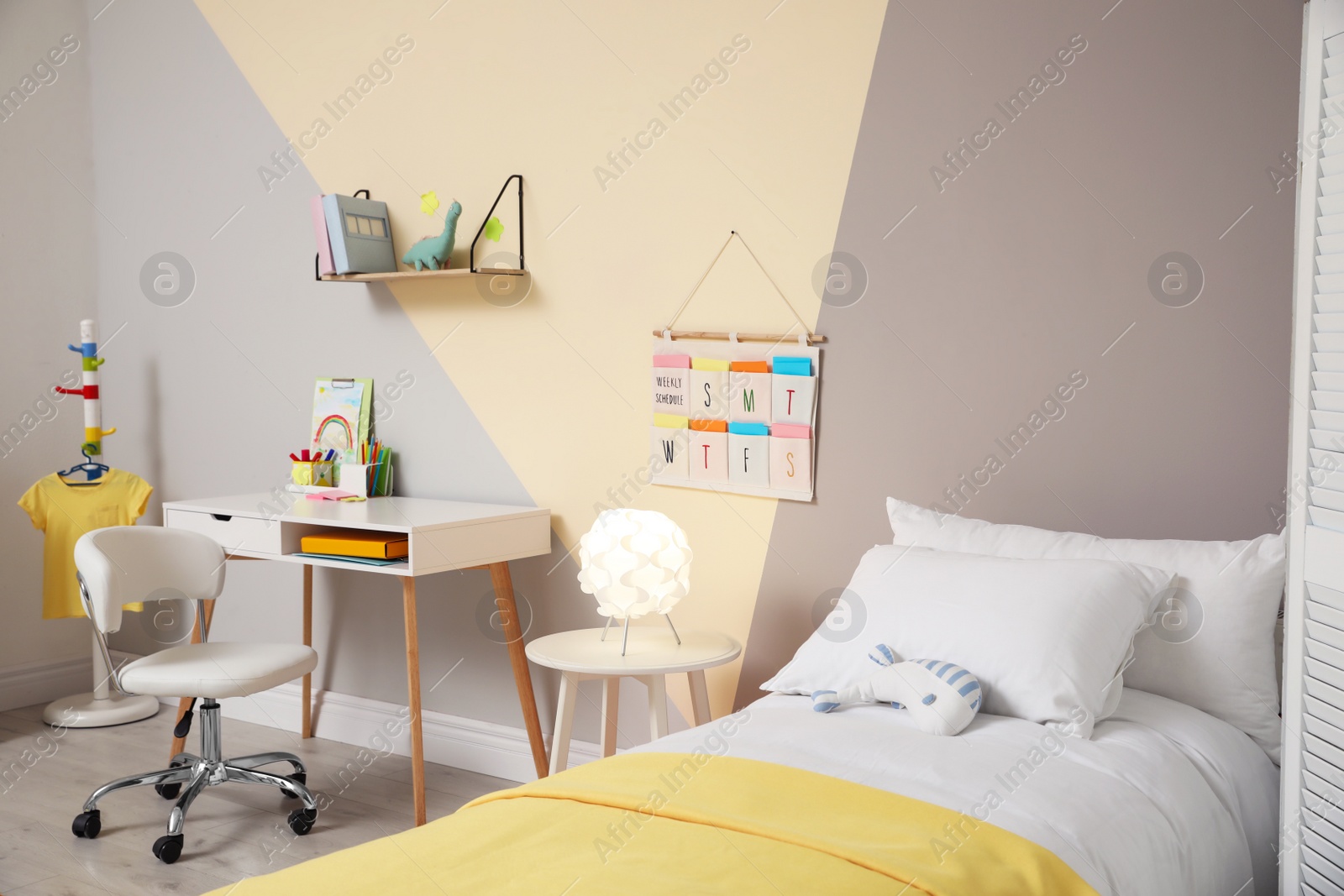 Photo of Stylish child room interior with comfortable bed and desk