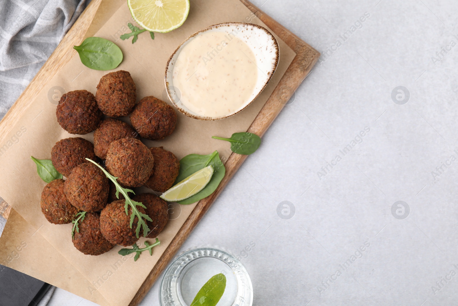 Photo of Delicious falafel balls served on light table, top view. Space for text