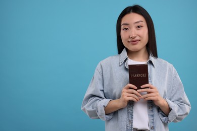 Immigration. Woman with passport on light blue background, space for text