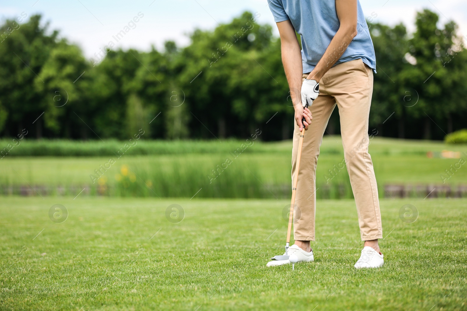 Photo of Man playing golf on green course. Sport and leisure