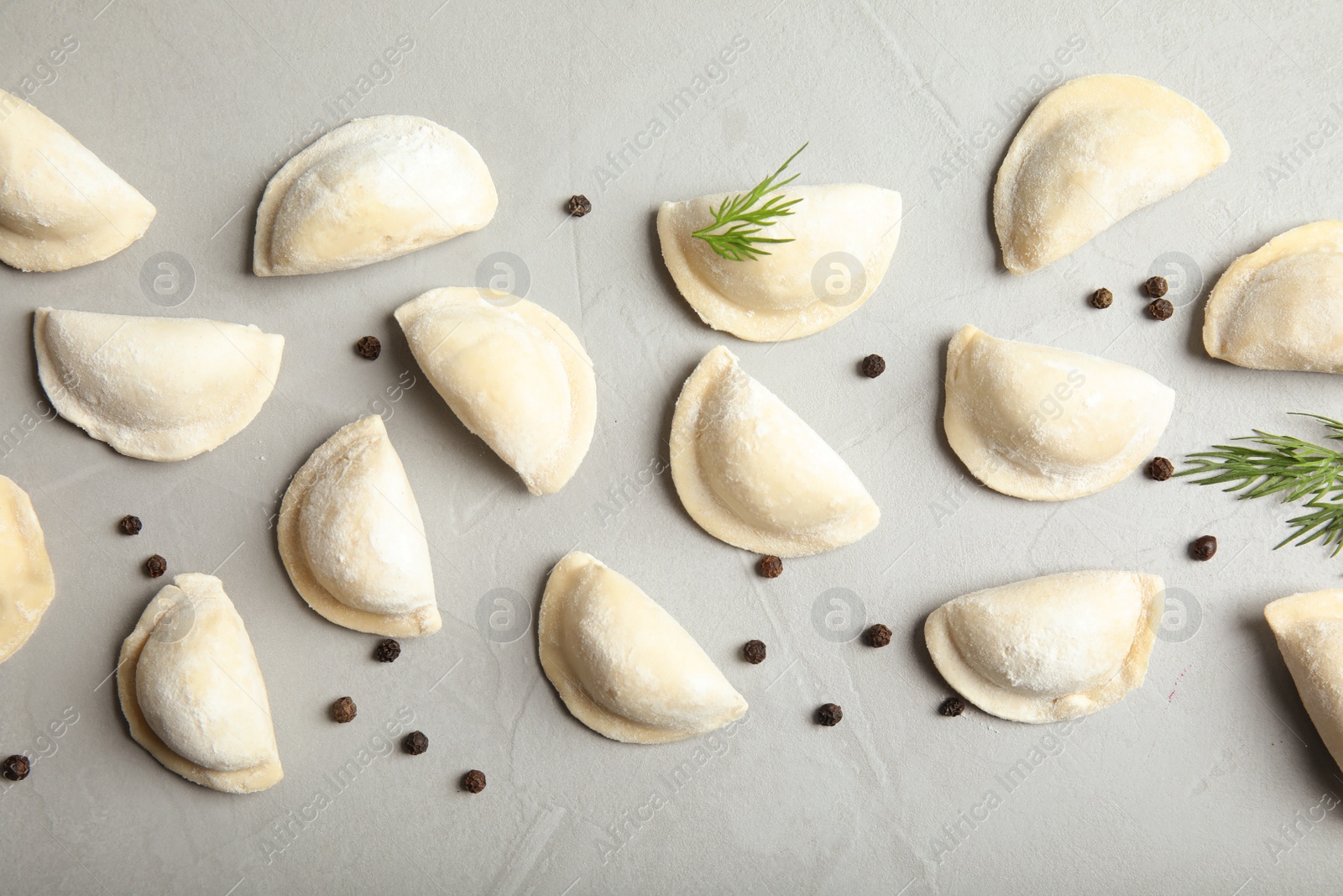 Photo of Flat lay composition with raw dumplings on grey background