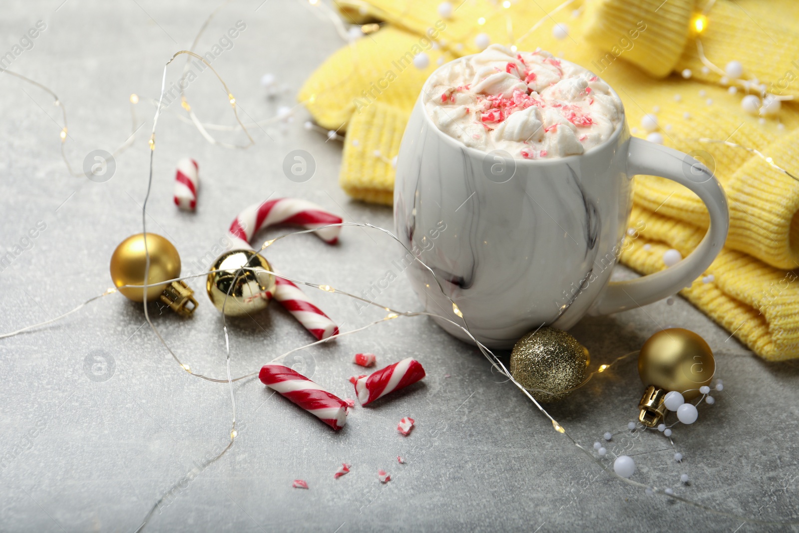 Photo of Composition with delicious marshmallow drink, festive decor and yellow sweater on light grey table