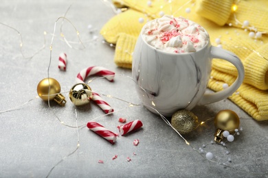 Composition with delicious marshmallow drink, festive decor and yellow sweater on light grey table