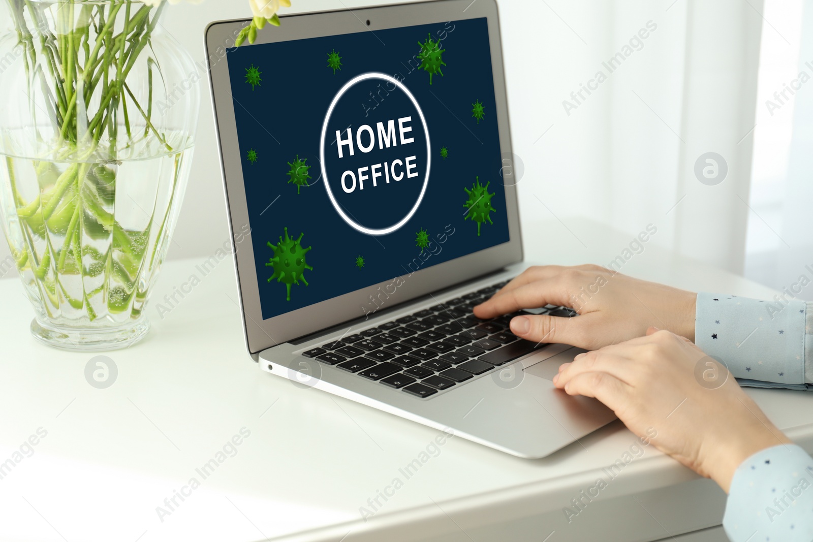 Image of Woman working with laptop at white table indoors, closeup. Home office