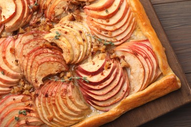 Freshly baked apple pie with nuts on wooden table, top view