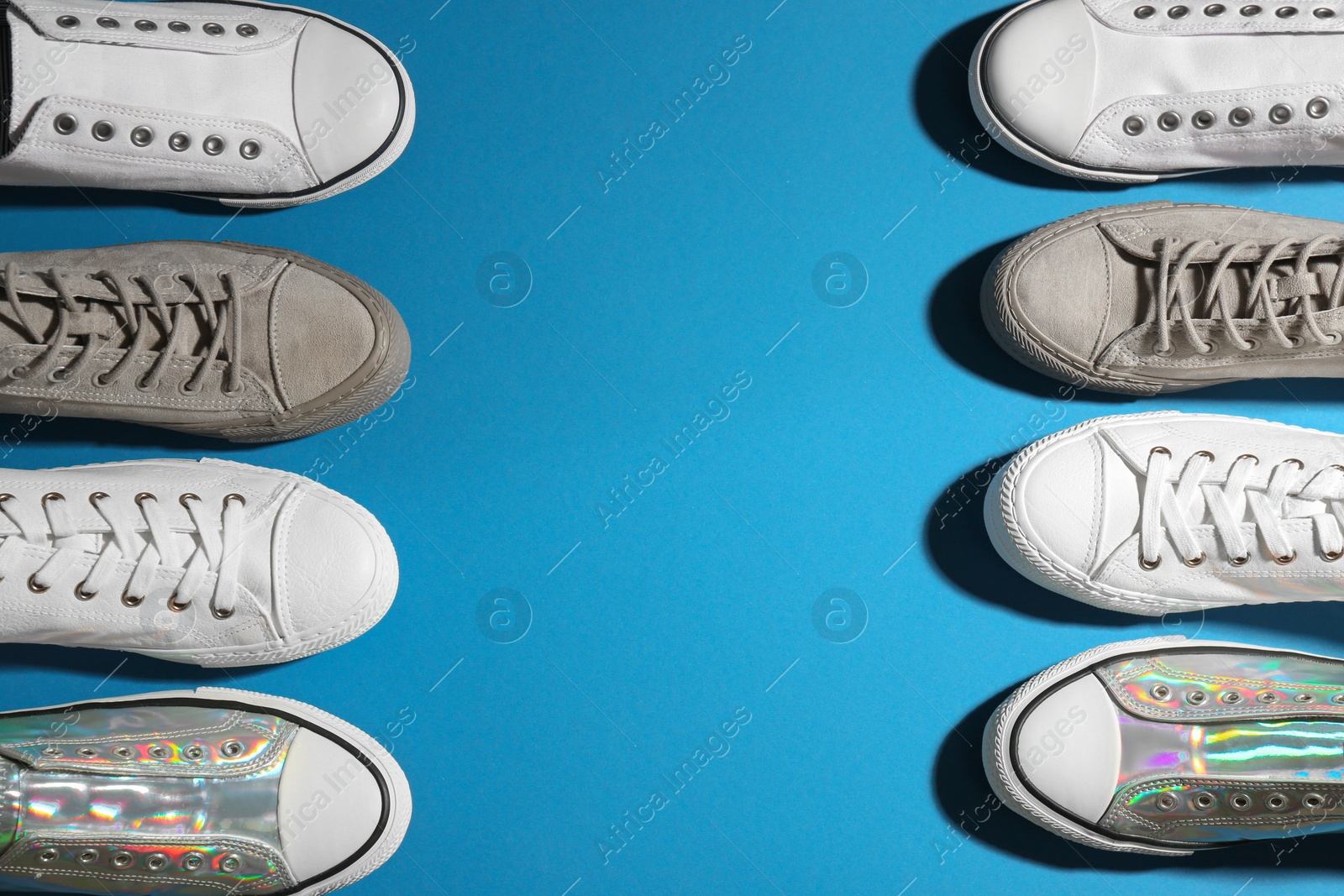 Photo of Flat lay composition with stylish sneakers on color background, space for text