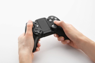 Photo of Young woman holding video game controller on white background, closeup