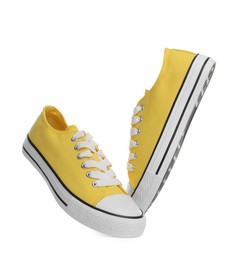 Photo of Pair of yellow classic old school sneakers on white background