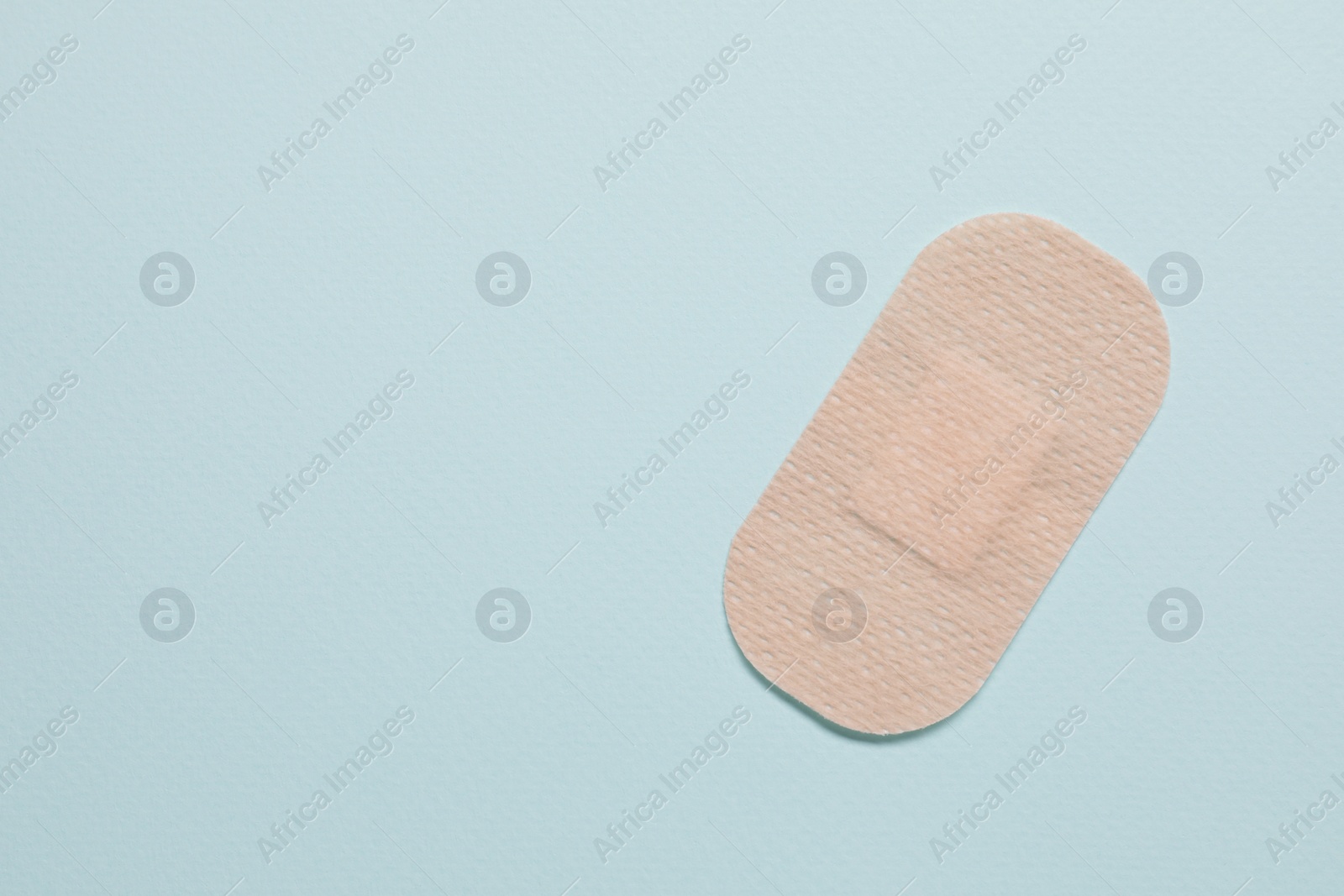 Photo of Contraceptive patch on light blue background, top view. Space for text