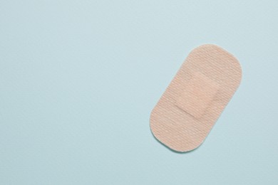 Photo of Contraceptive patch on light blue background, top view. Space for text