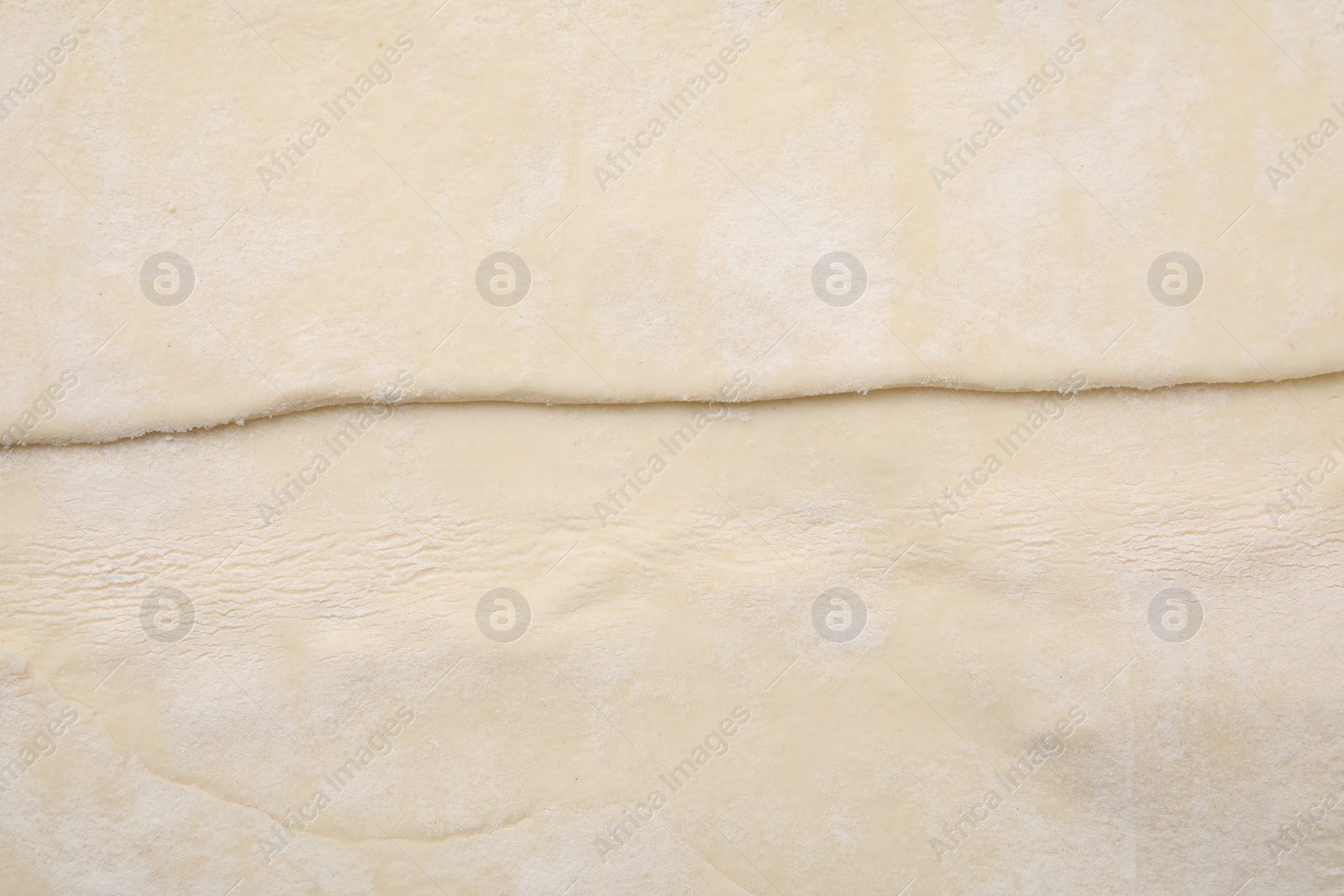 Photo of Raw puff pastry dough as background, top view