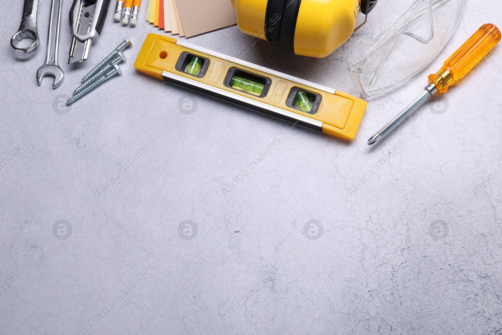 Photo of Flat lay composition with building level and other construction tools on grey table, space for text