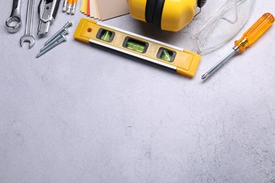 Photo of Flat lay composition with building level and other construction tools on grey table, space for text