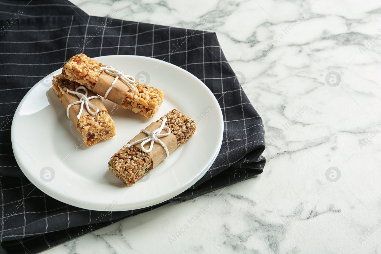 Photo of Plate with different homemade grain cereal bars on marble table