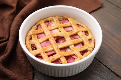 Baking dish with tasty apple pie on wooden table, closeup