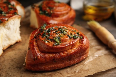 Photo of Traditional Ukrainian bread (Pampushky) with garlic on wooden table, closeup