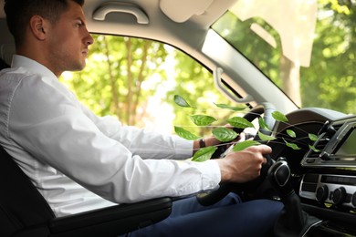 Man driving car feeling tea leaves scent from ventilation, closeup. Air freshener