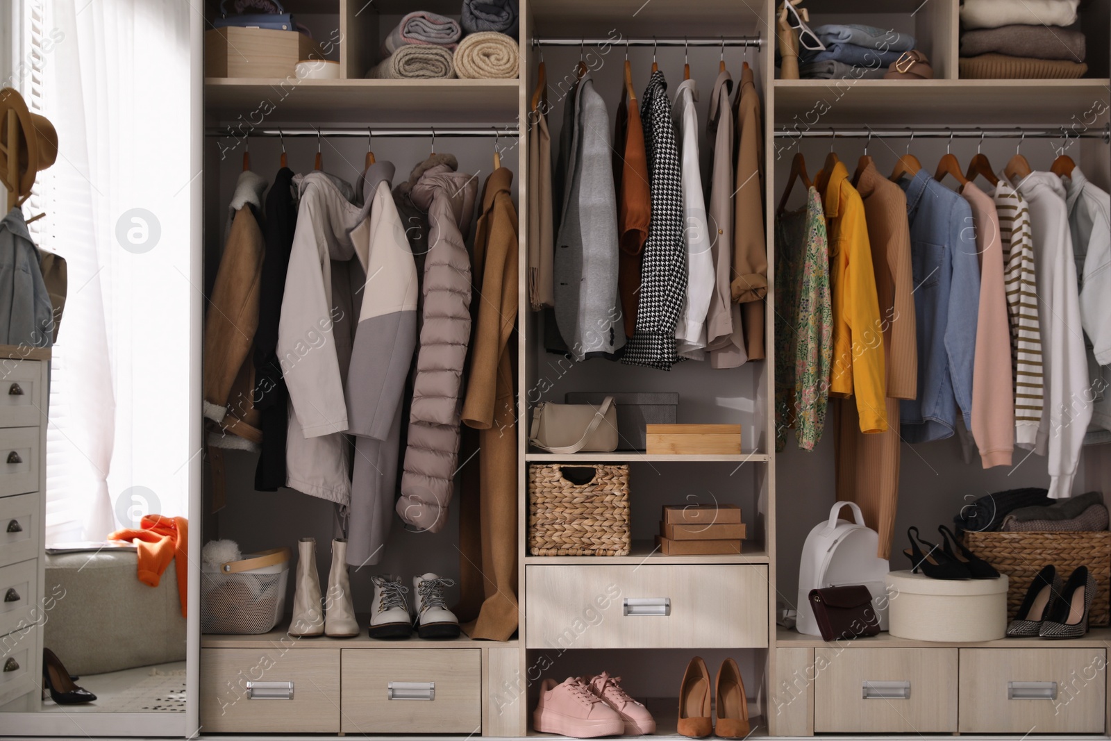 Photo of Wardrobe closet with different stylish clothes, shoes and home stuff in room