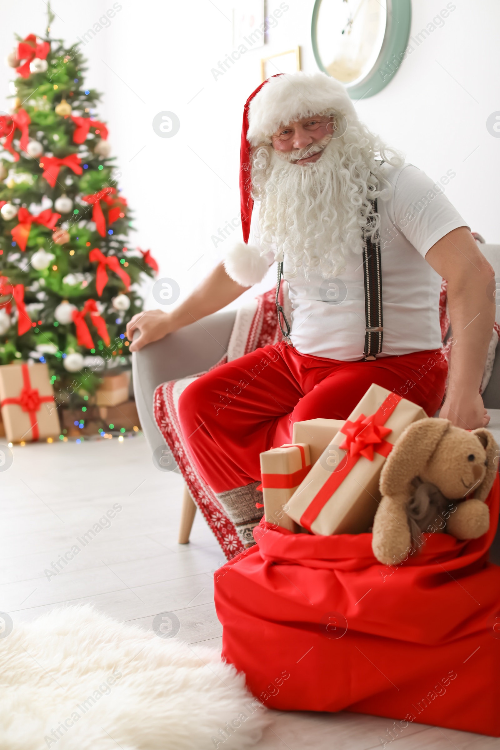 Photo of Authentic Santa Claus with bag of gifts indoors