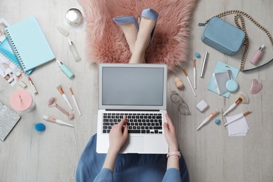 Beauty blogger with laptop on floor, top view