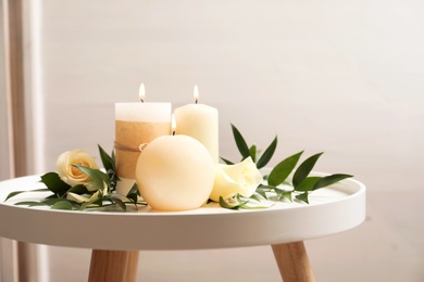 Beautiful composition with burning candles and flowers on table