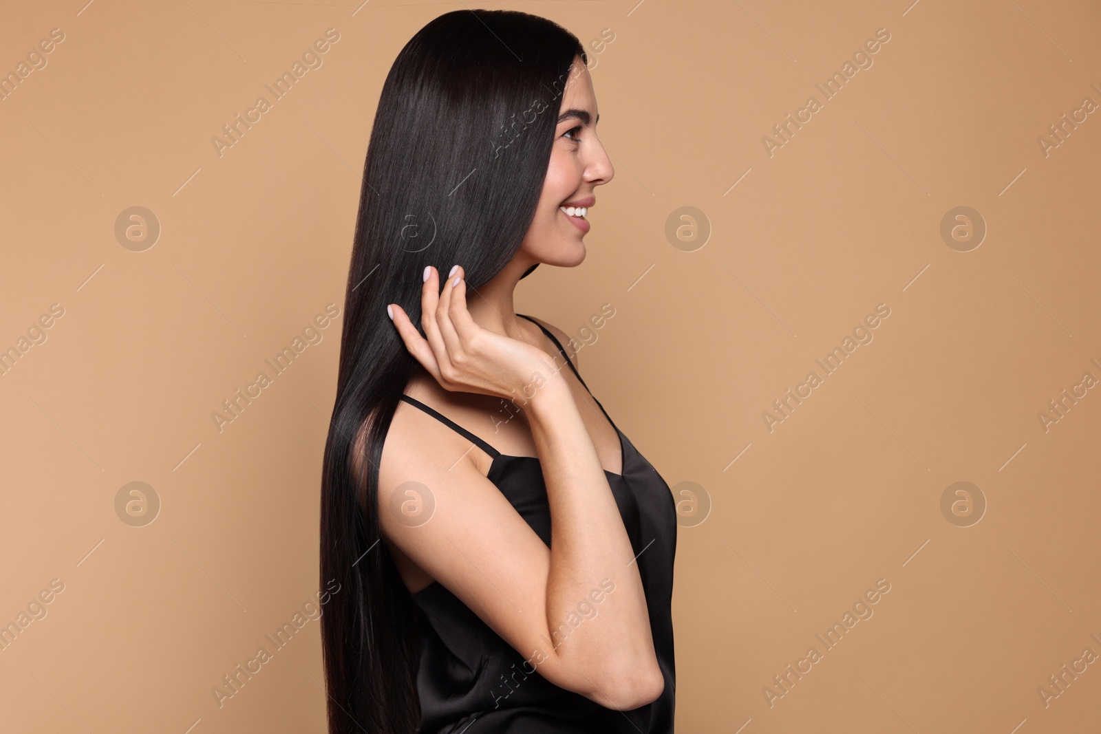 Photo of Beautiful young woman with healthy strong hair on beige background