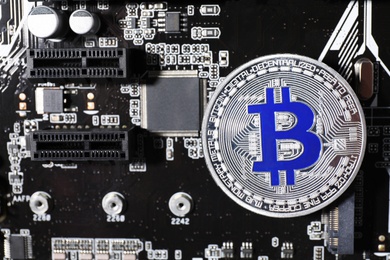 Photo of Silver bitcoin on computer circuit board, top view. Space for text