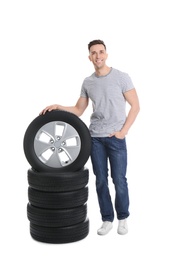 Young man with car tires on white background