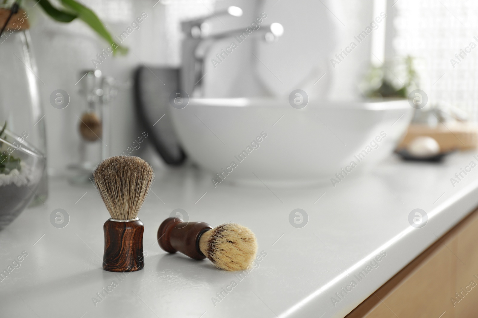 Photo of Shaving brushes on light countertop in bathroom